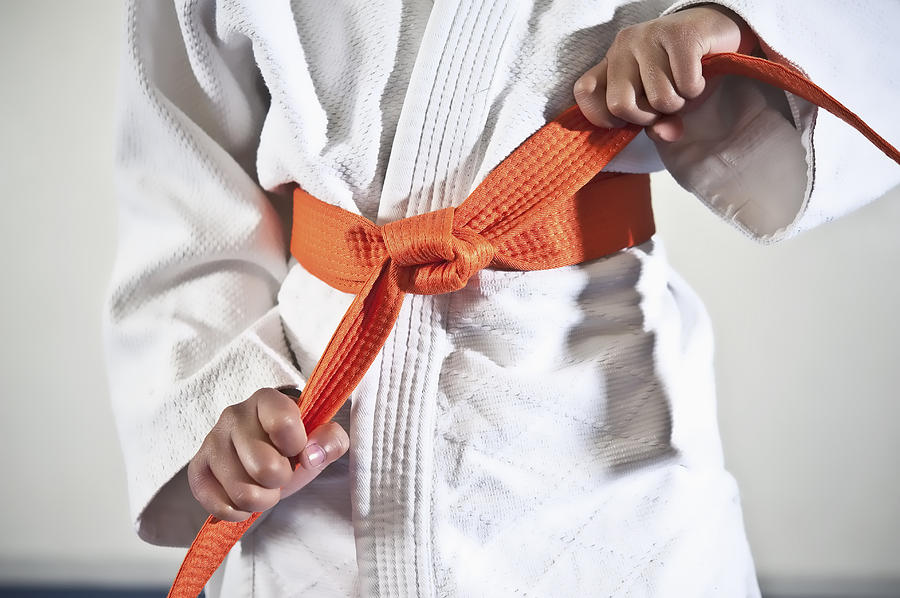 African American boy tightening karate belt Photograph by Jacobs Stock Photography Ltd