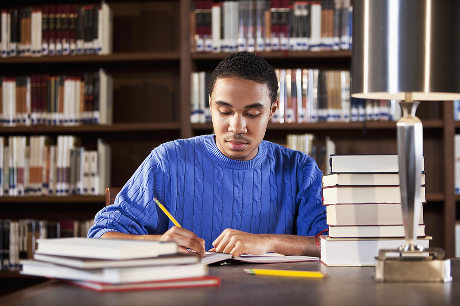 African American teenager studying in library Photograph by Kali9