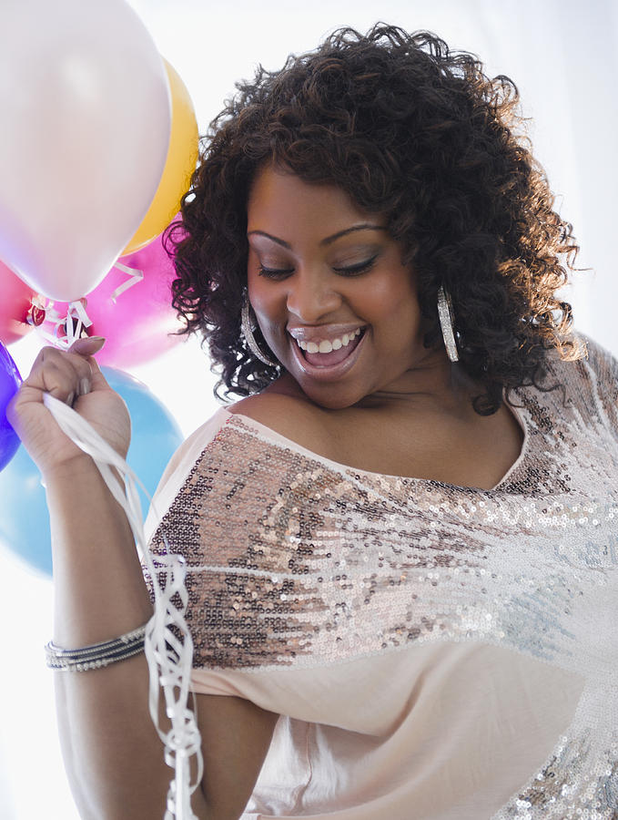 African American woman holding balloons Photograph by JGI/Jamie Grill