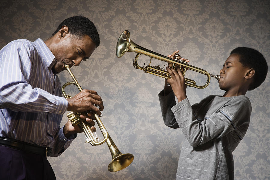 African man and boy playing trumpets Photograph by Hill Street Studios