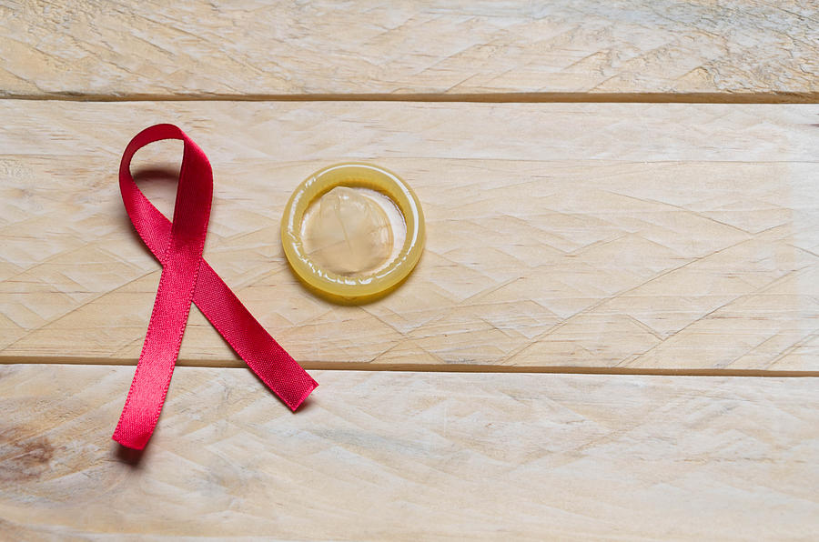 AIDS awareness red ribbon and condom Photograph by Elizabeth Fernandez