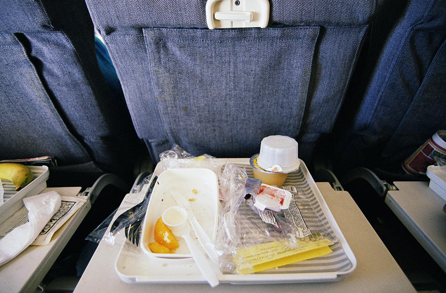 Airline food wrappers and utensils on tray, elevated view Photograph by Bryan Mullennix