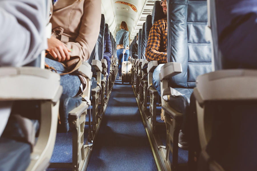 Airplane interior with people sitting on seats Photograph by Izusek