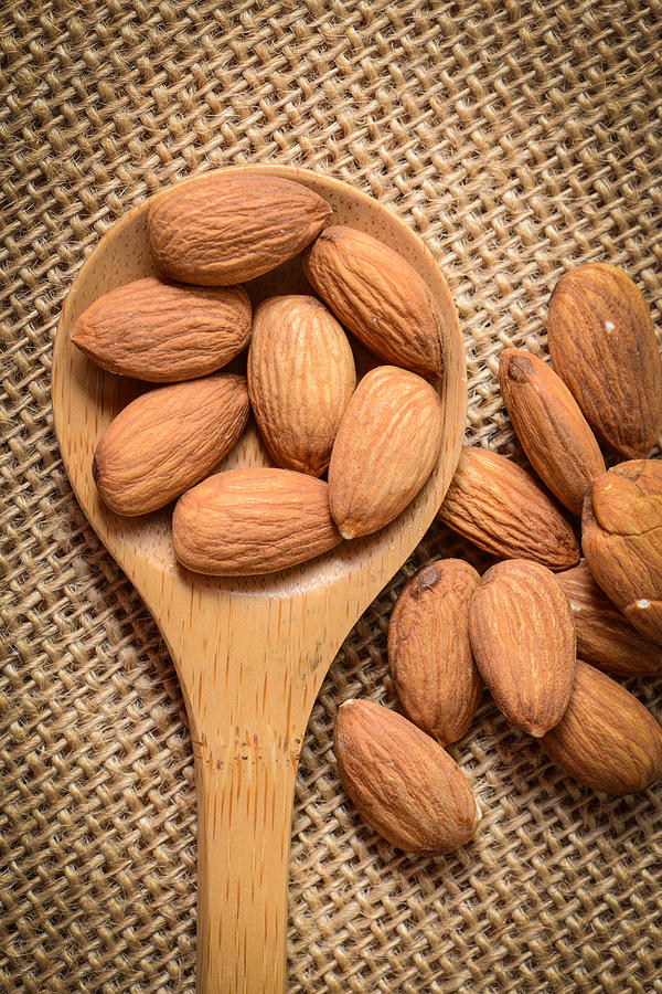 Almonds in a Wodden Spoon on a Burlap Background Photograph by Brandon Bourdages