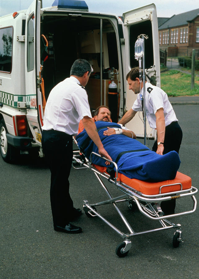 Ambulancemen Loading Patient Into Ambulance Photograph by Adam Hart