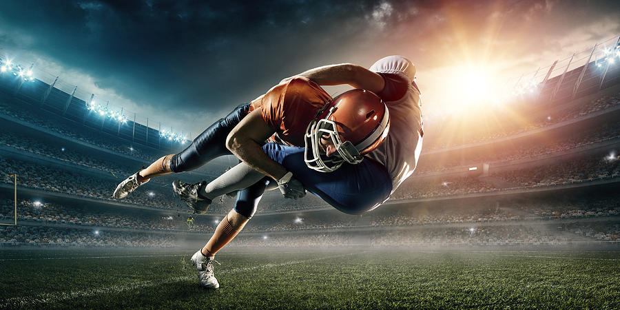 American football player being tackled Photograph by Dmytro Aksonov