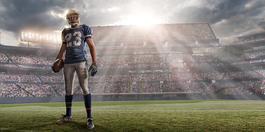 American Football Player in Sunlit Stadium Photograph by Peepo