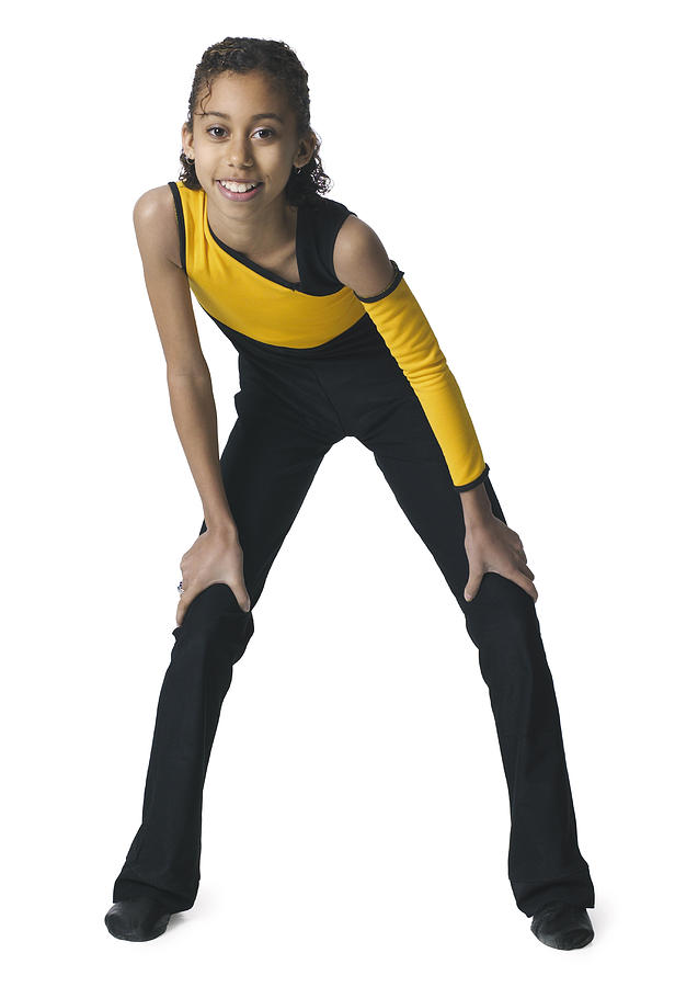 An African American Female Child In A Yellow And Black Leotard Leans Forward To Stike A Dance Pose Photograph by Photodisc
