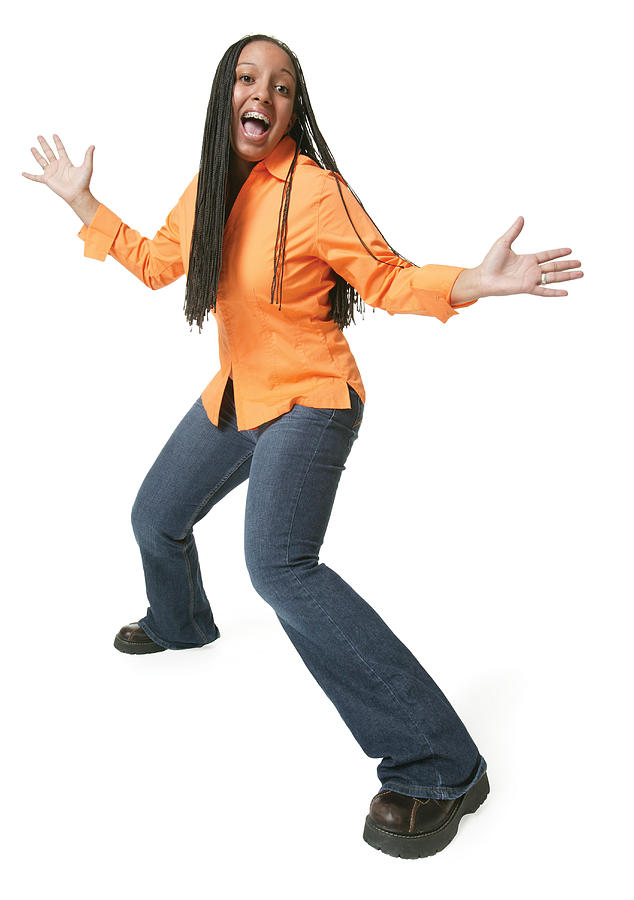 An African American Teenage Girl In Jeans And An Orange Shirt Spreads Out Her Arms And Smiles Big Photograph by Photodisc