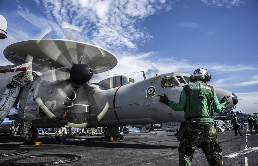 An aircraft director directs an E-2C Hawkeye aboard USS George Washington. Photograph by Stocktrek Images