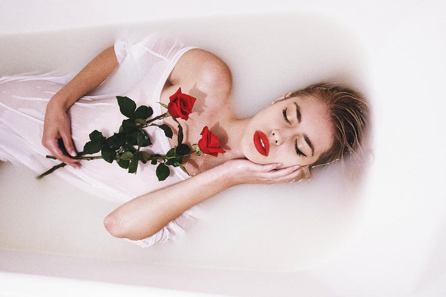 An attractive young woman lies in milk bath Painting by Jovana Rikalo.