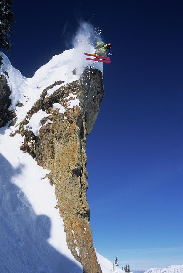 Winter Photograph - An Extreme Skier Jumps Off A Snowy by Jeff Diener
