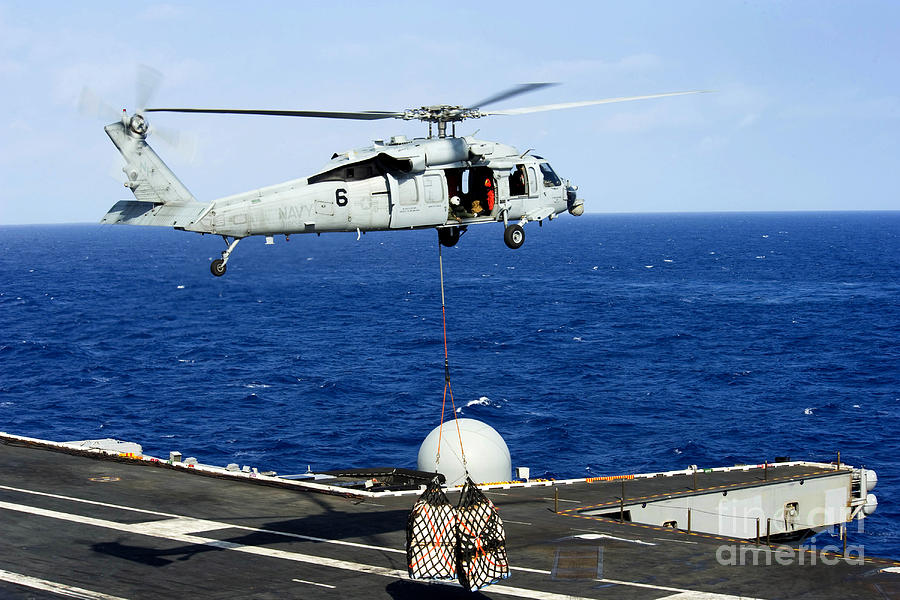 An SH-60B Seahawk helicopter performs a vertical replenishment Poster Print  by Stocktrek Images - Item # VARPSTSTK101401M - Posterazzi