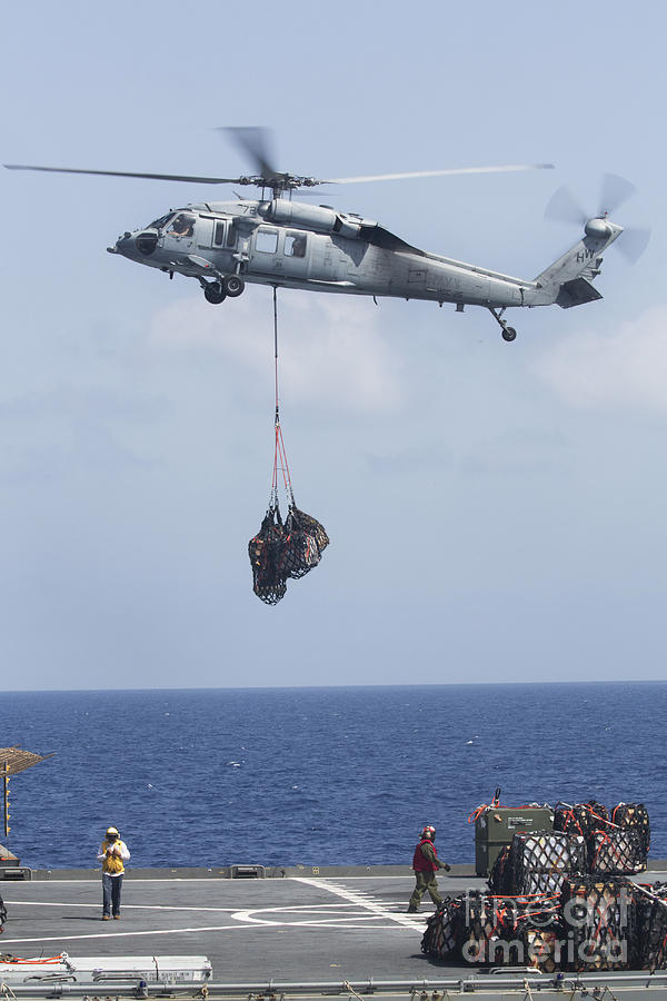 Transportation Photograph - An Mh-60s Sea Hawk Picks Up Cargo by Stocktrek Images