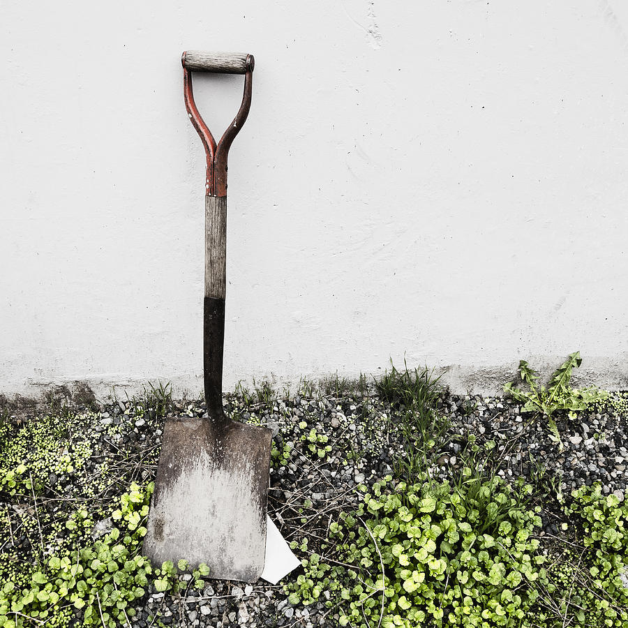 An old shovel propped against a wall. Photograph by Mint Images