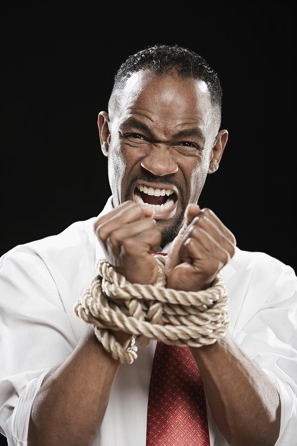 Angry African man with wrists bound by rope Photograph by Hill Street Studios