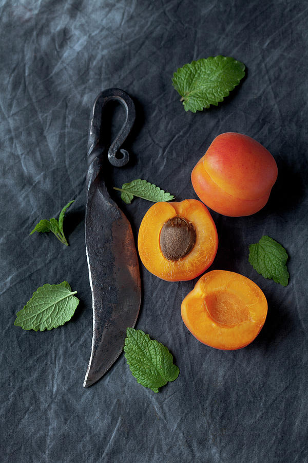 Apricots With Leaves And Knife On Black Photograph by Westend61