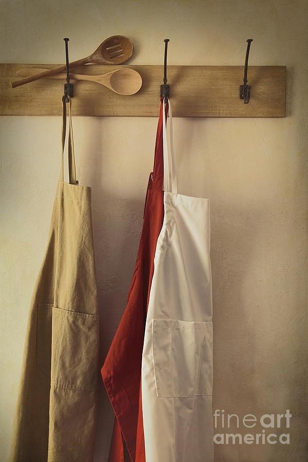 Aprons hanging on hooks with vintage feel Photograph by Sandra Cunningham