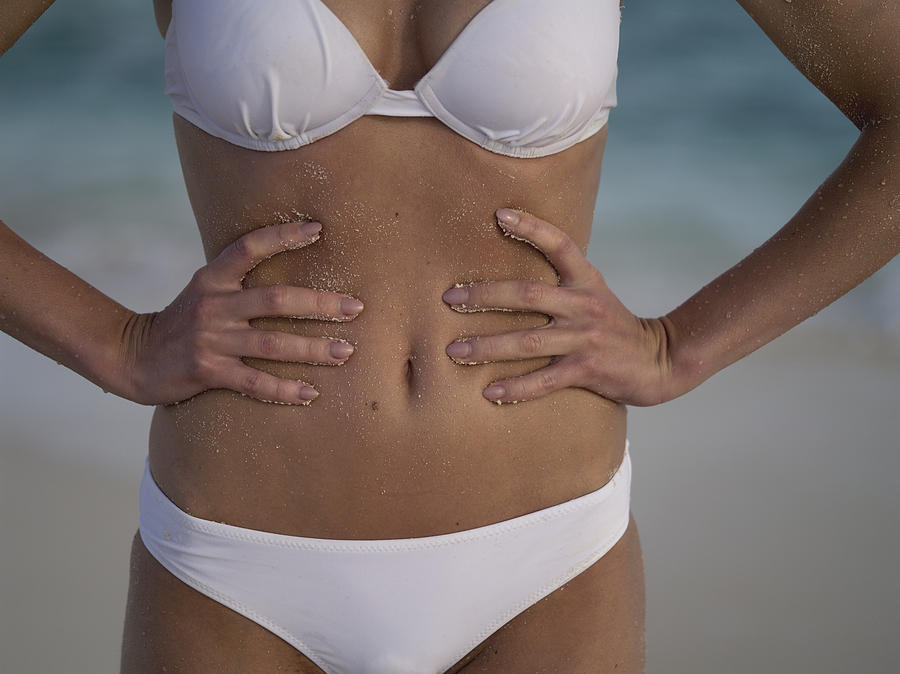 Asia, Maldives, Close Up Of Young Caucasian Womans Tummy On A Tropical Beach Alone Photograph by Kypros