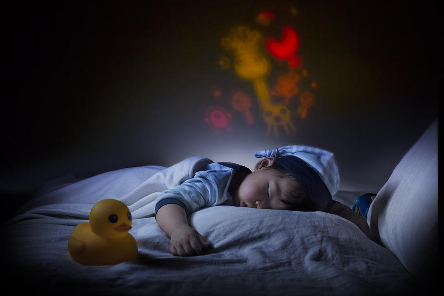 Asian toddler boy sleeping in the dark. Photograph by Twomeows