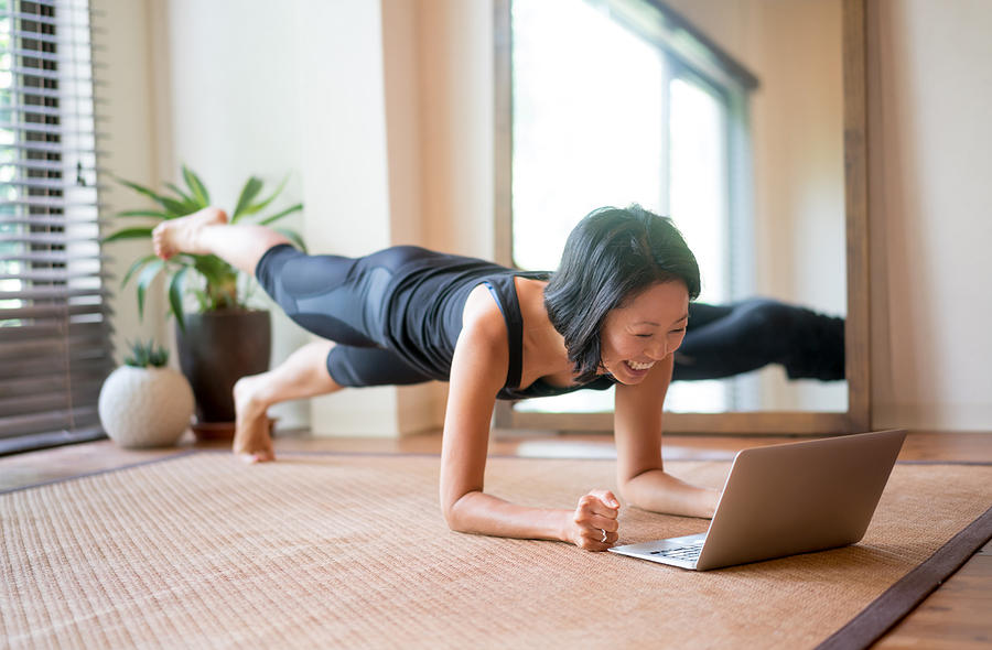 Asian woman exercising at home Photograph by Andresr