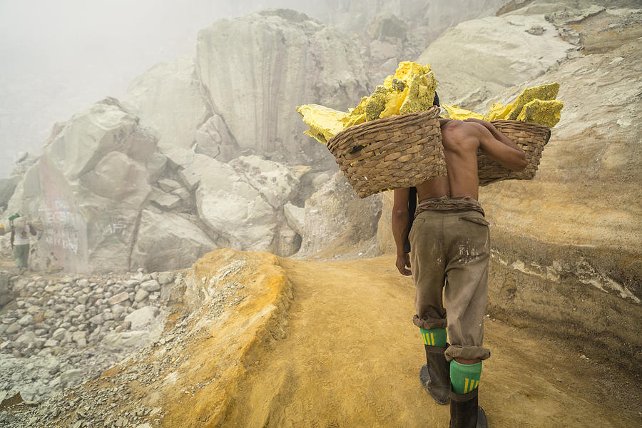 Asian worker carrying baskets of sulfur in Ijen volcano Photograph by Joakimbkk