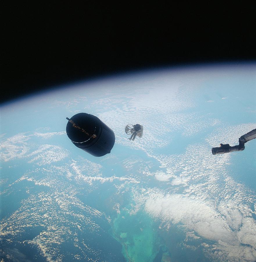 Astronaut Rescuing A Damaged Satellite. Photograph by Nasa/science Photo Library.
