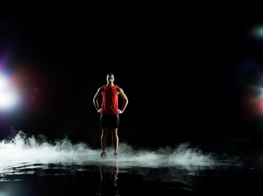 Athelete Standing In Water At Night Photograph by Jonathan Knowles