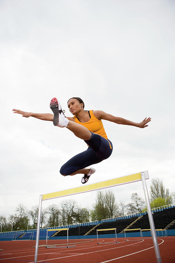 Athlete Clearing A Hurdle Photograph by Gustoimages/science Photo Library