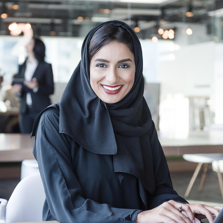 Attractive Arab businesswoman wearing hijab smiling towards camera Photograph by JohnnyGreig