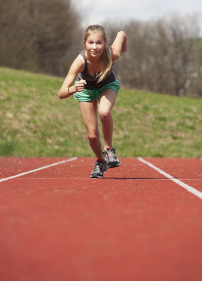 Austria, Teenage girl running on track, portrait Photograph by Westend61