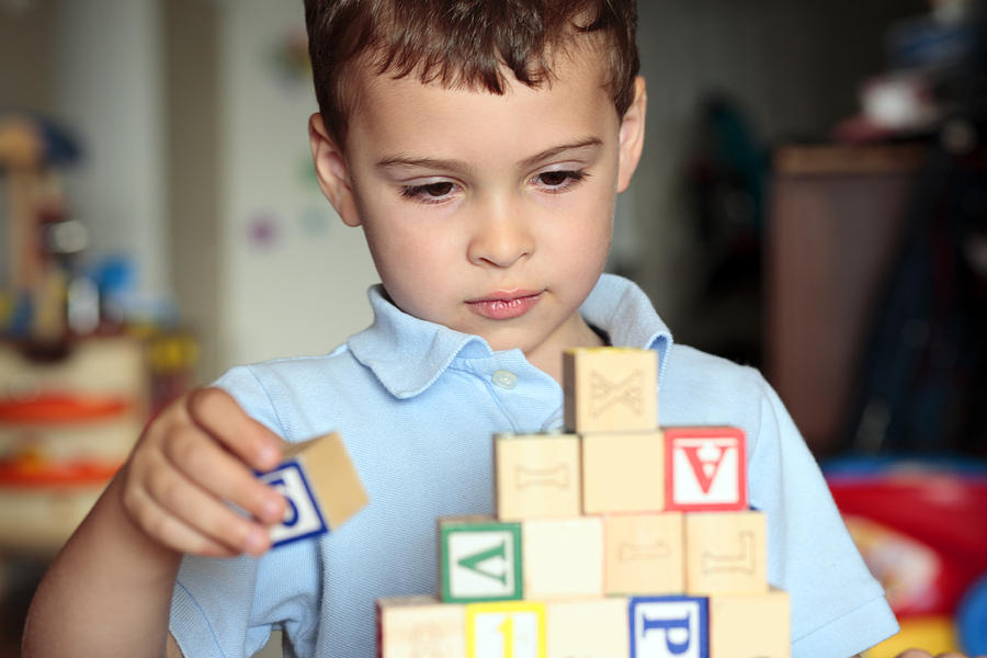 Autistic boy building with blocks Photograph by UrsaHoogle
