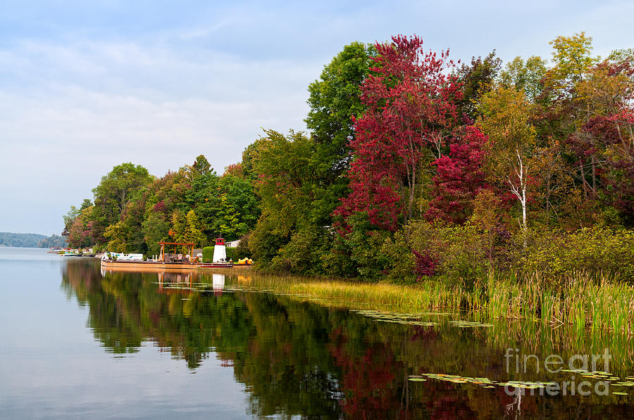 Autumn lake scene with a toy lighthouse and colorful trees Photograph by Les Palenik