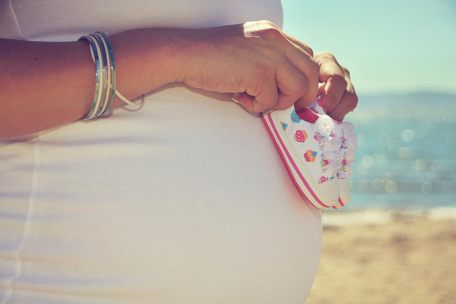 Portrait Photograph - Baby Booties on a Baby Bump on the Beach by Laurie Search