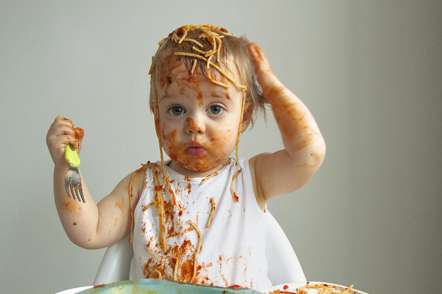 Baby boy getting messy eating spaghetti Photograph by Flashpop