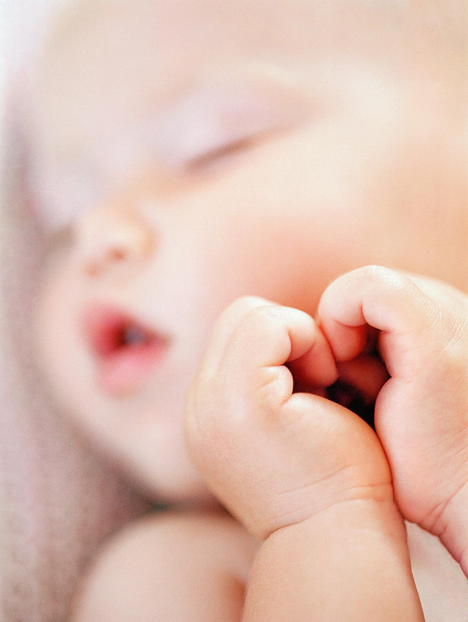 Baby girl (9-12 months) sleeping, close-up (focus on hands) Photograph by Laurence Monneret