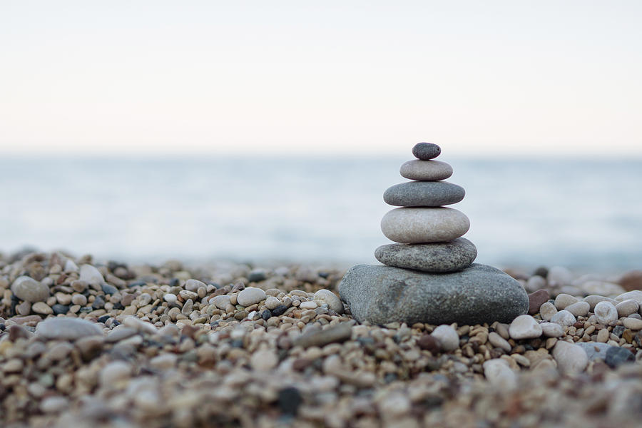 Balanced stones on a pebble beach Photograph by Burak Karademir