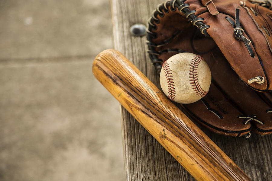 Baseball season is here. Bat, glove and ball on dugout bench. Photograph by Fstop123 Baseball season is here. Bat, glove and ball on dugout bench. Photograph by Fstop123