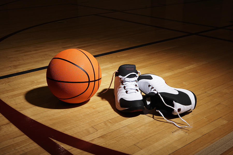 Basketball and sports shoes on basketball court Photograph by Thomas Northcut