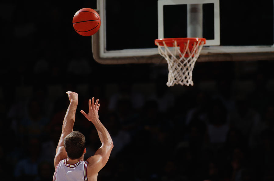 Basketball player shooting from free throw line, rear view Photograph by David Madison