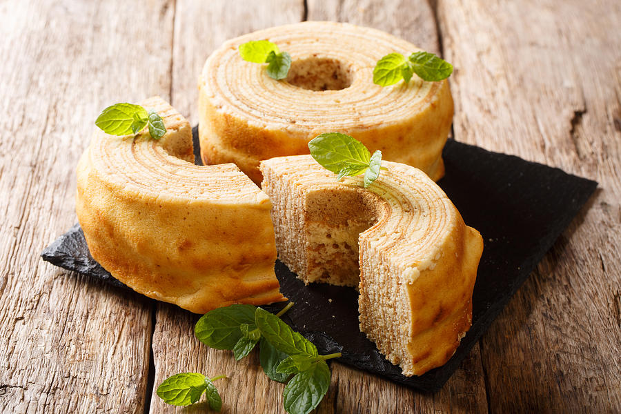 Baumkuchen, translated as tree cake, is a many-layered sponge cake baked on a rotating cylinder close-up. horizontal Photograph by Alleko