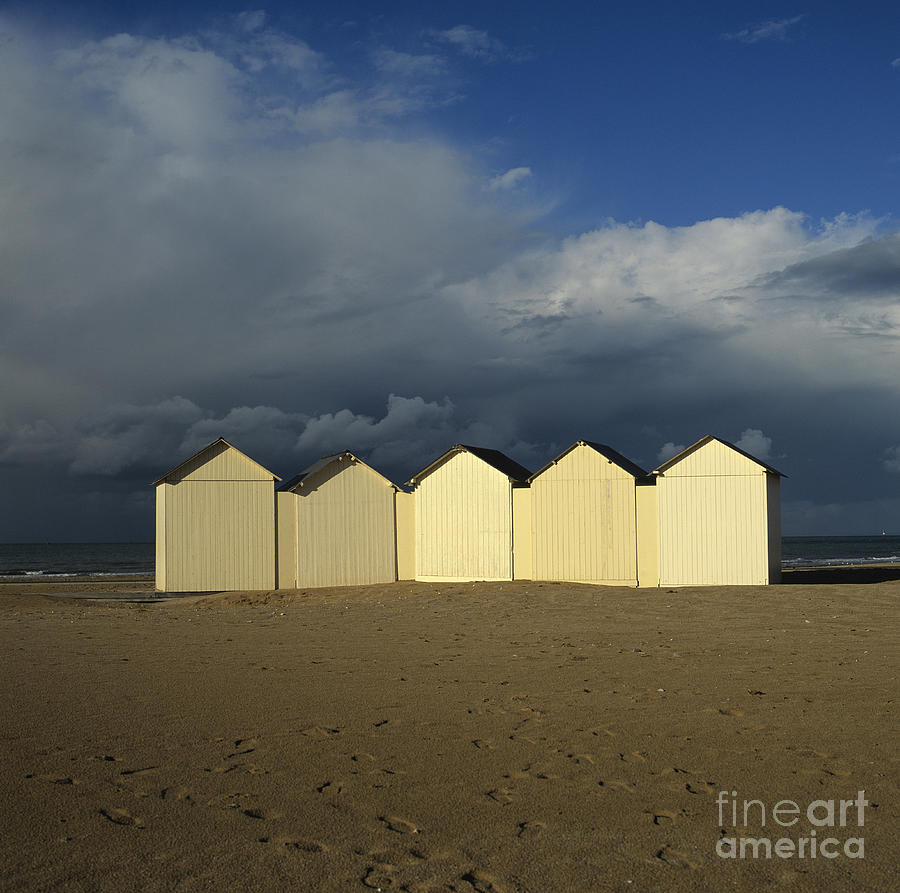 Beach Photograph - Beach huts under a stormy sky in Normandy by Bernard Jaubert