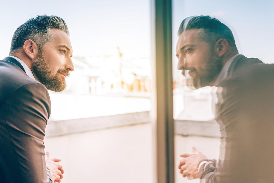 Bearded Business Man Reflecting Himself In Window Glass Photograph by Golero