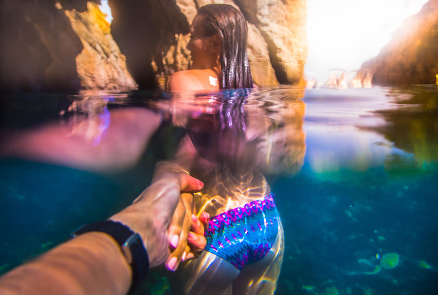 Beautiful and sensual girl lead the way holding hands of a guy taken the picture from personal point of view with underwater view in the Costa Brava during summer vacations. Follow me. Photograph by Artur Debat