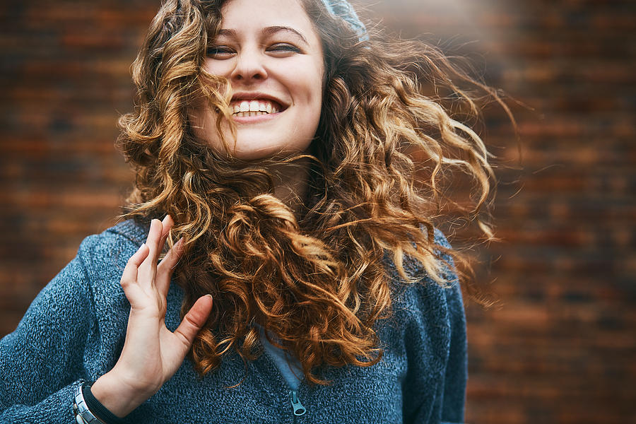 Beautiful girl with winter windblown hair laughs Photograph by RapidEye