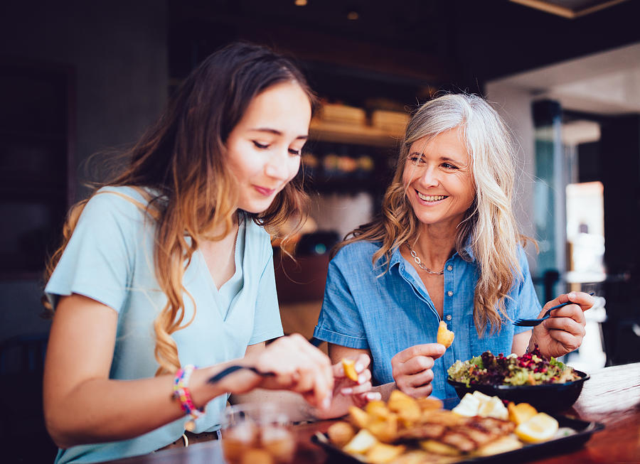 Beautiful senior mother and daughter eating lunch together at restaurant Photograph by Wundervisuals