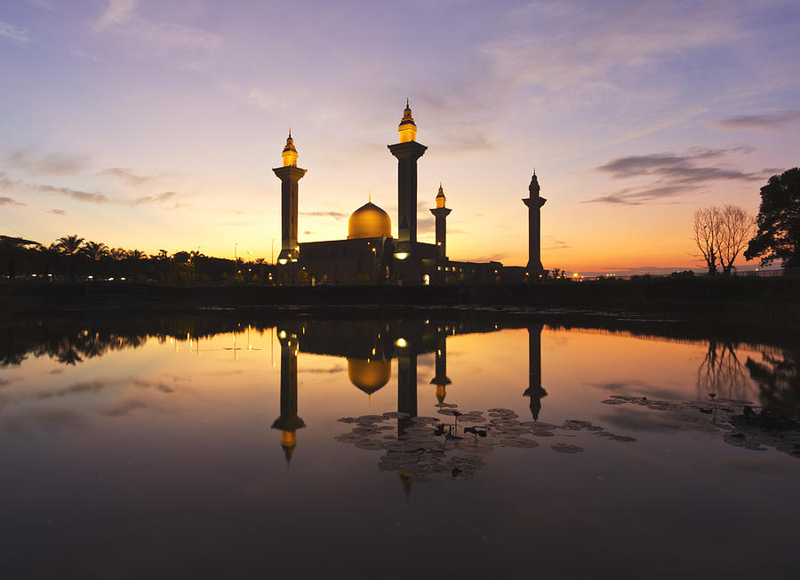Beautiful sunrise with silhouetted mosque reflected in the water. Photograph by Nazman Mizan