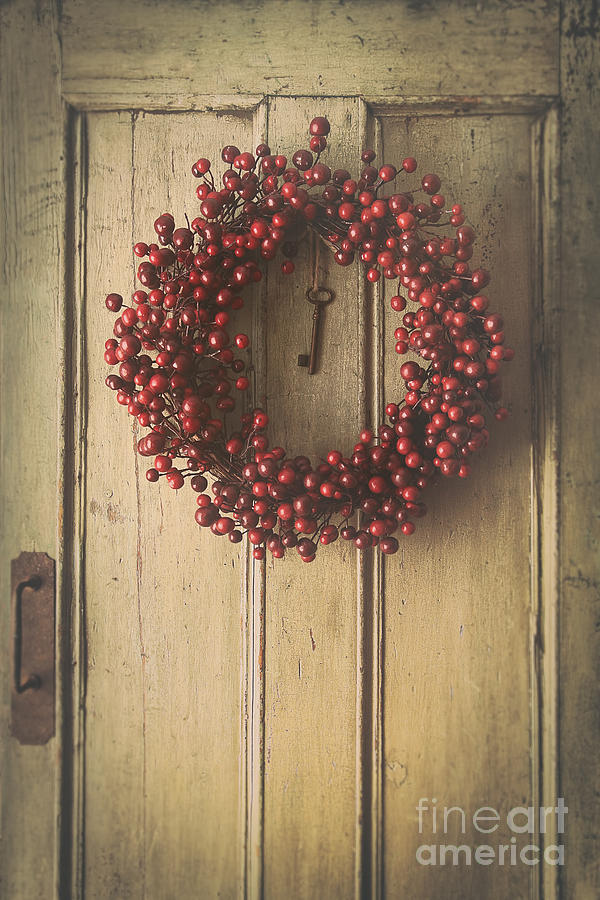 Berry wreath hanging on old wood door Photograph by Sandra Cunningham