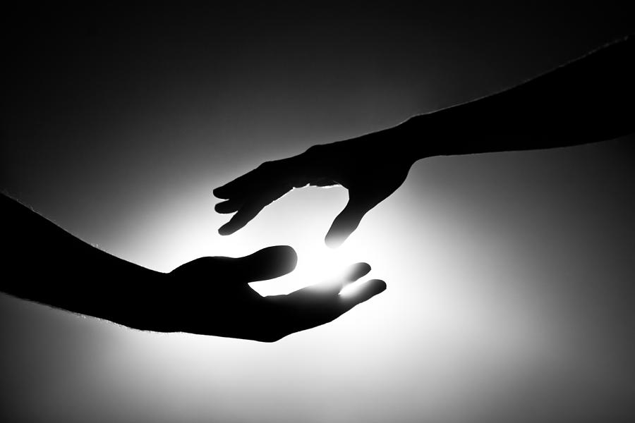 Black and white image of two hands reaching out Photograph by AMR Image