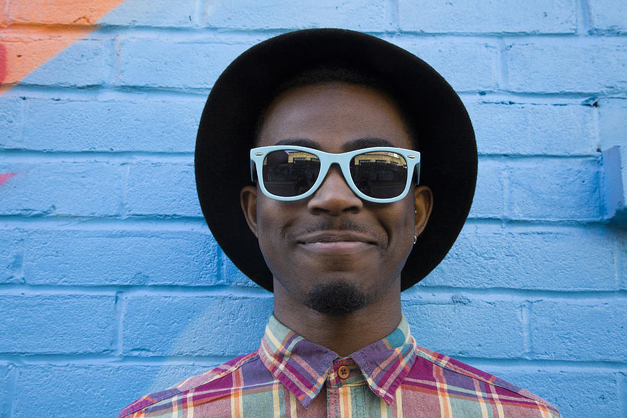 Black man wearing sunglasses near colorful wall Photograph by Verity Jane Smith